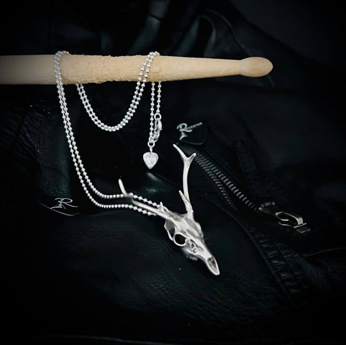 FAWN OF THE DEAD deer pendant photographed with a high-shine ball chain draped over a drumstick