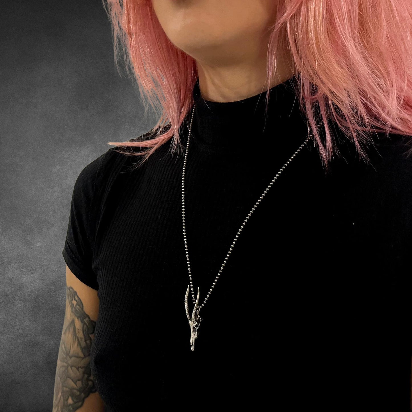 NO GRAZING BACK senegal hartebeest skull pendant on 24-inch oxidised ball chain, photographed on tattooed, pink-haired model