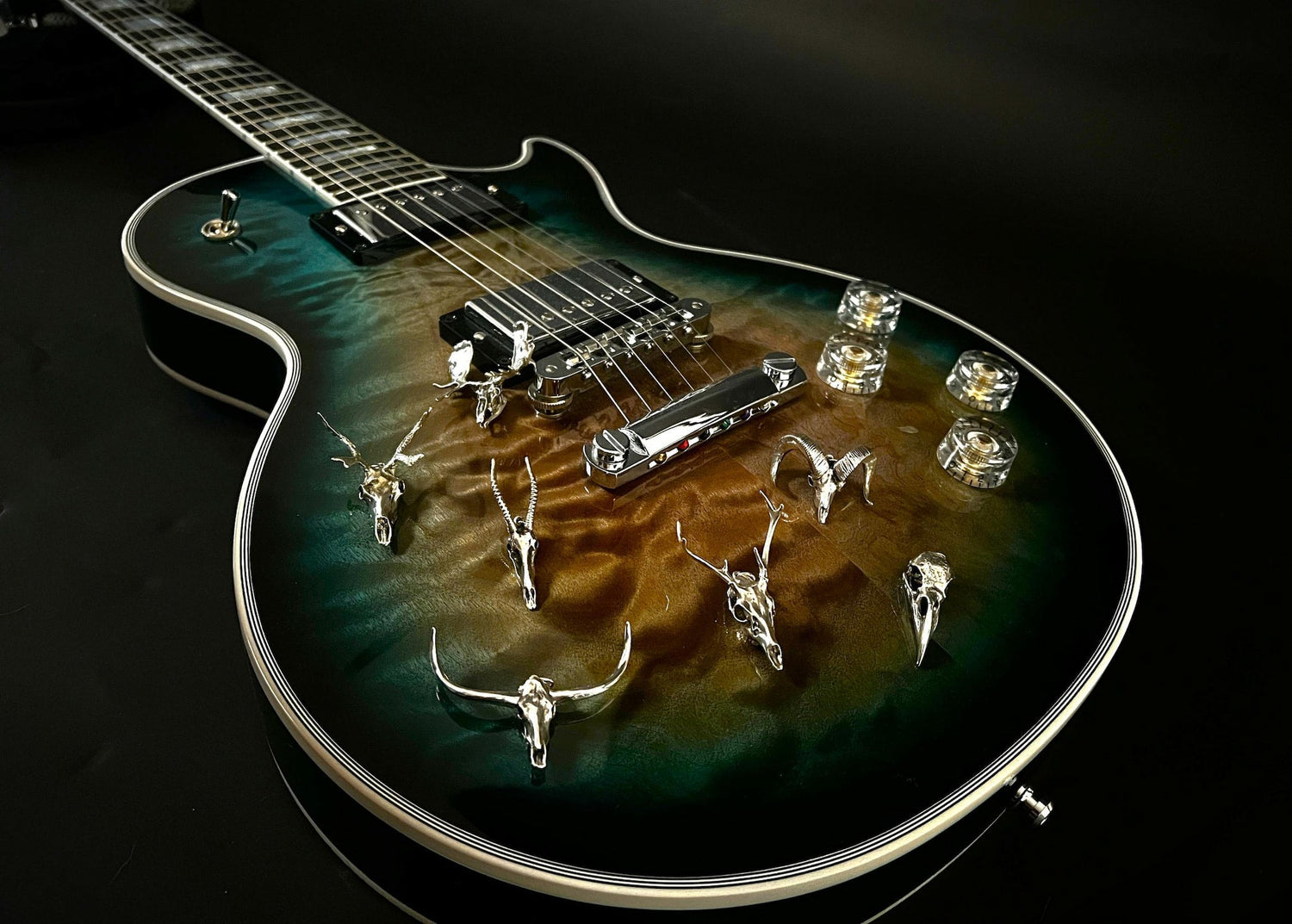 Fine-silver jewellery from the FIRE & BONE collection, displayed on a Gibson Custom Shop guitar