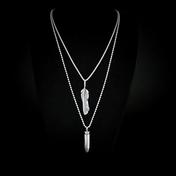 Silver layered necklaces with feather and vial lockets on a black background — ONE-STEP COOL collection by ROCKSTAR★REFINEMENTS