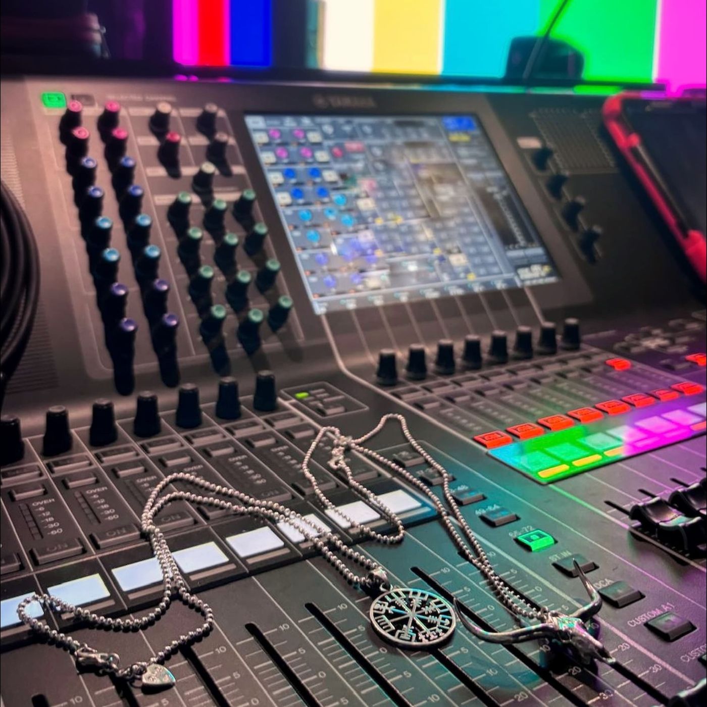 Sterling silver pendant necklaces styled on a backstage sound mixing desk at a live music setup