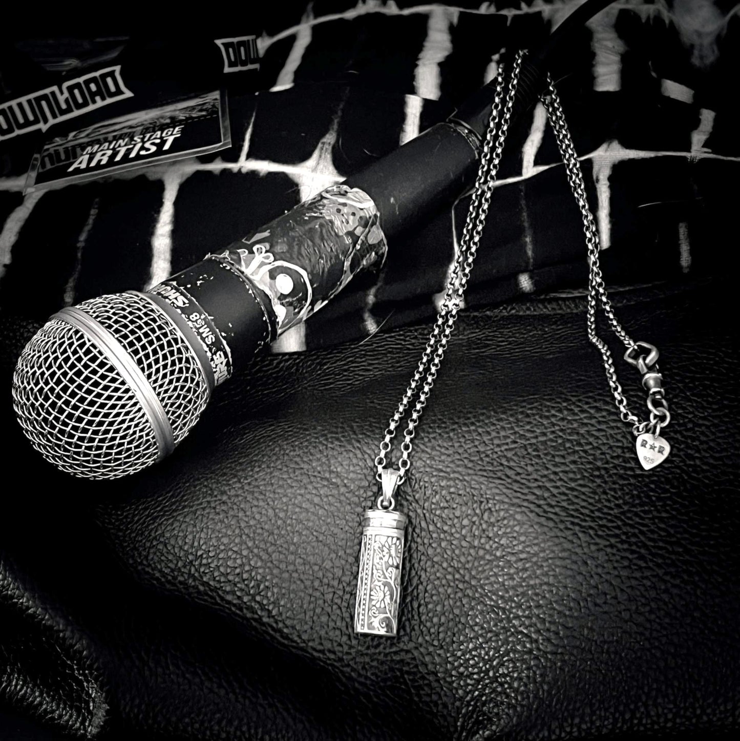 sterling silver ANTIDOTE (NOT INCLUDED) locket pendant resting on  the microphone after a gig. 