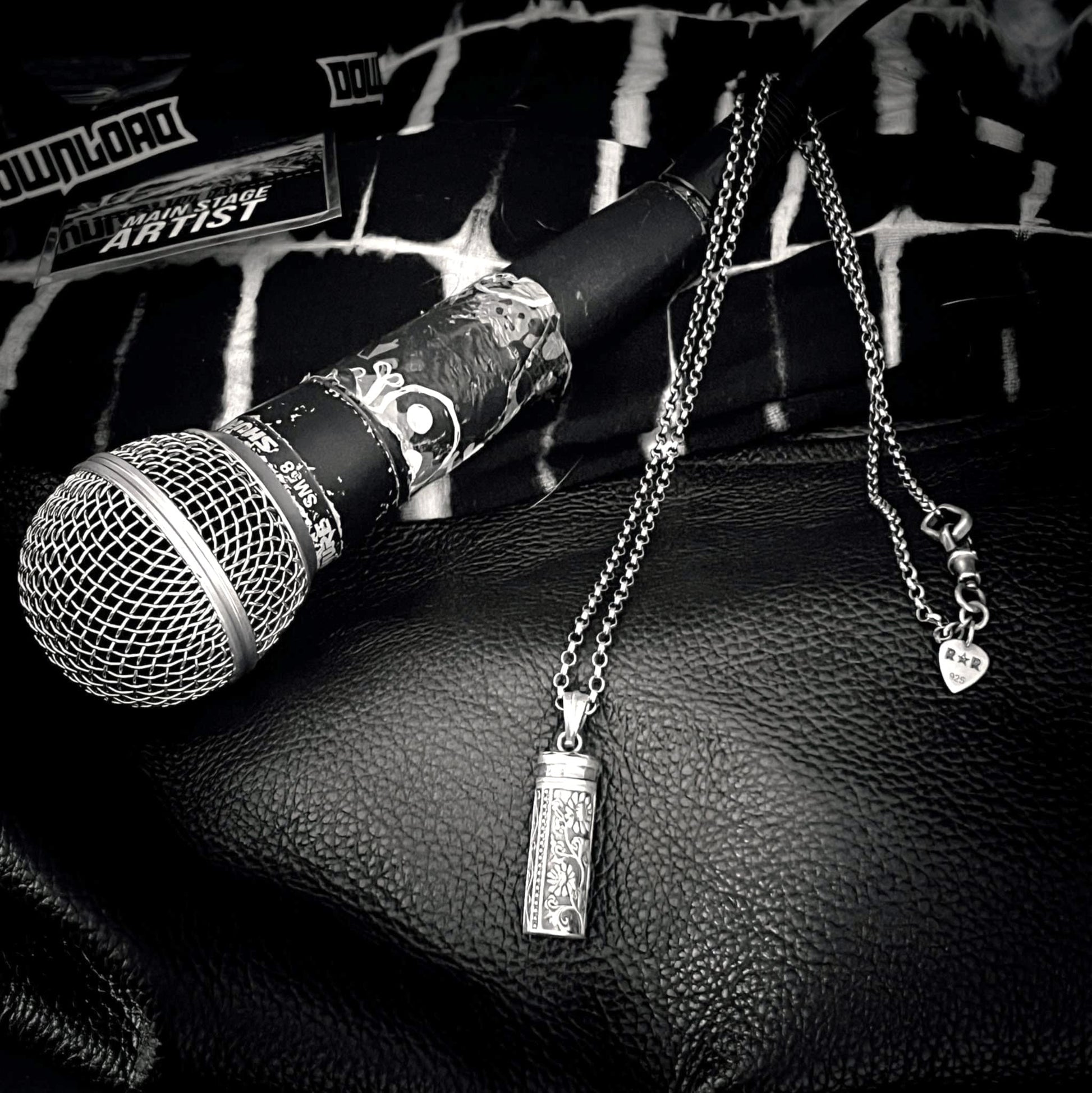 sterling silver ANTIDOTE (NOT INCLUDED) locket pendant resting on  the microphone after a gig. 