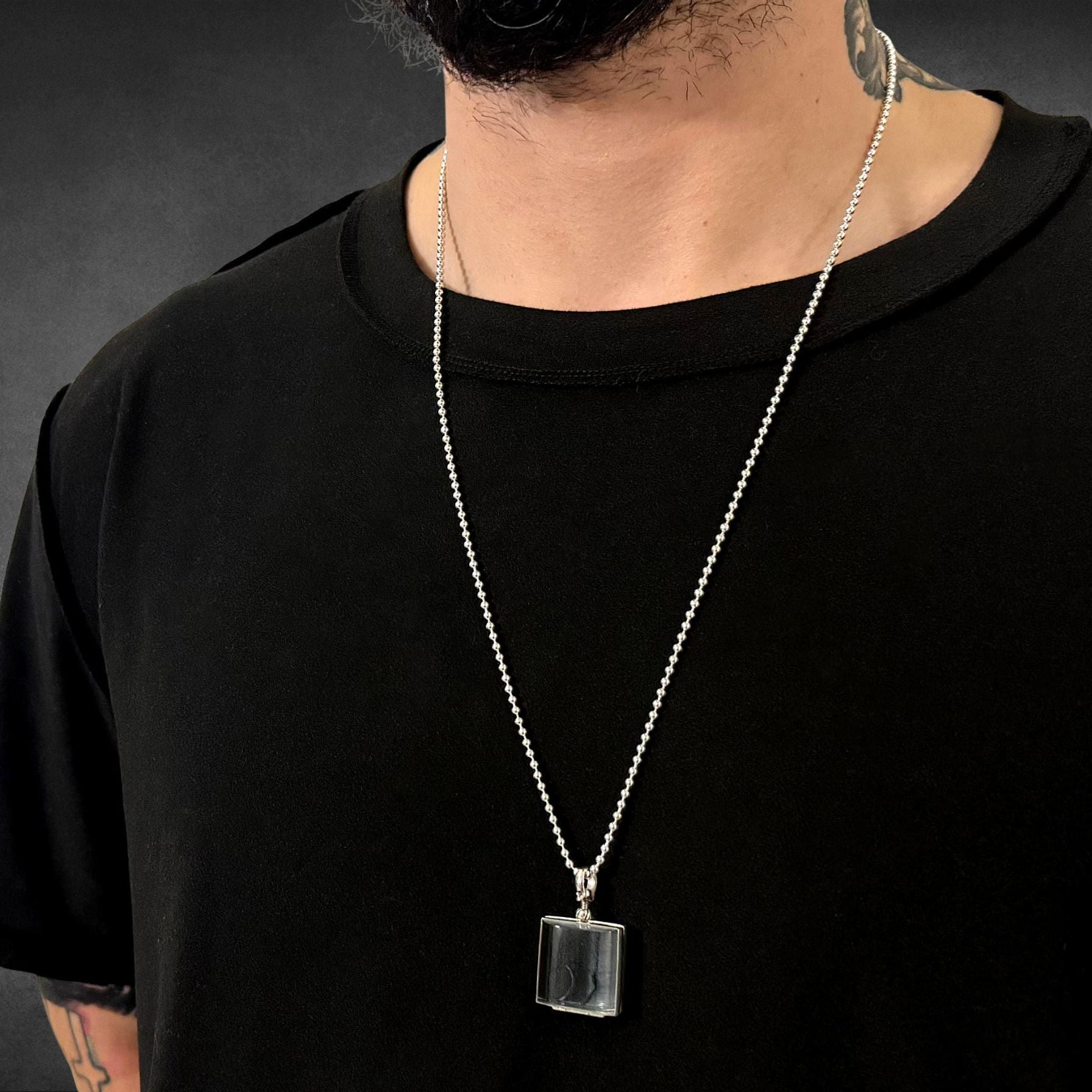 ASHES OF HIS HOODIE pendant on 28 inch high-shine ball chain worn by male model on grey background