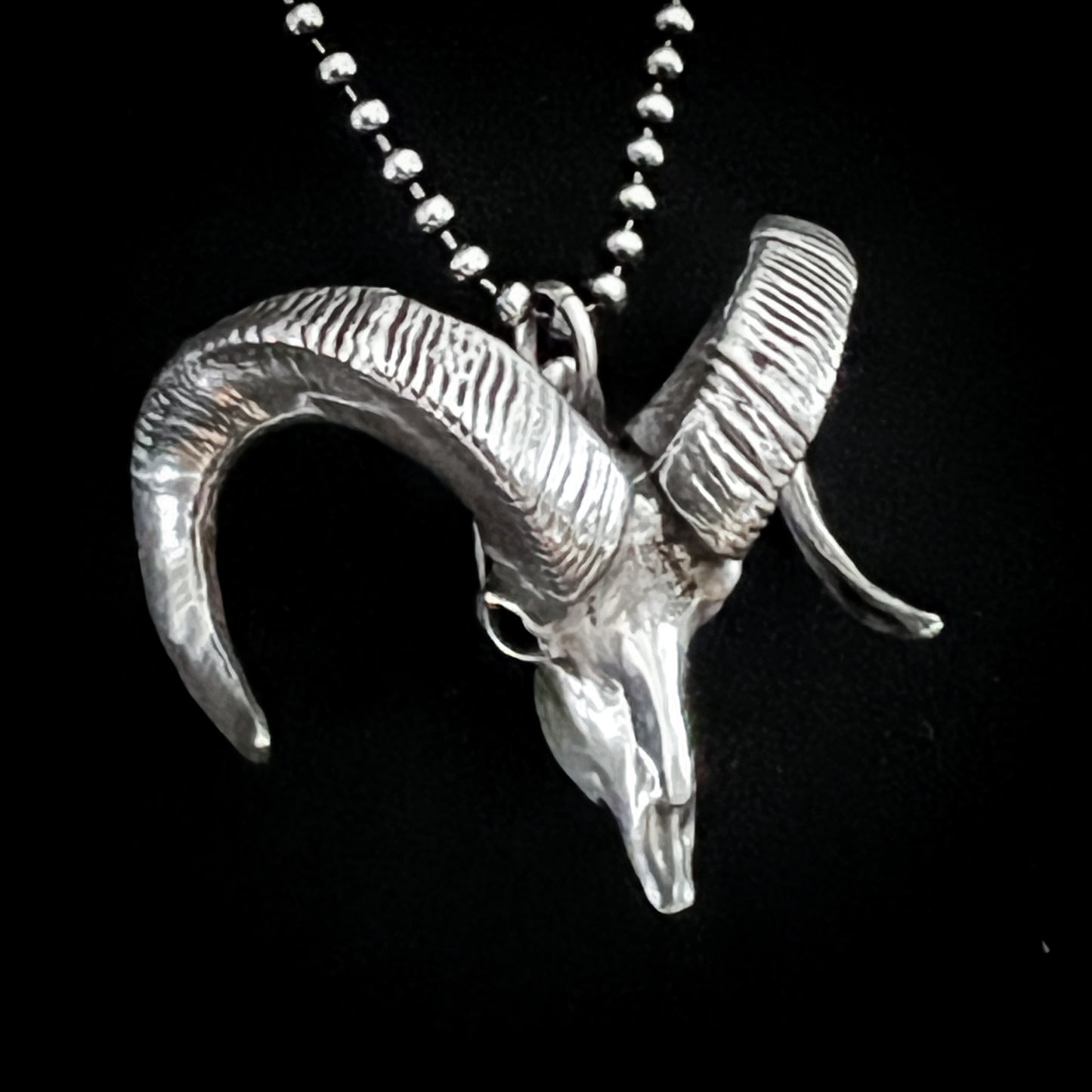 Sterling silver bighorn sheep skull pendant called Born to Headbang, shown close up