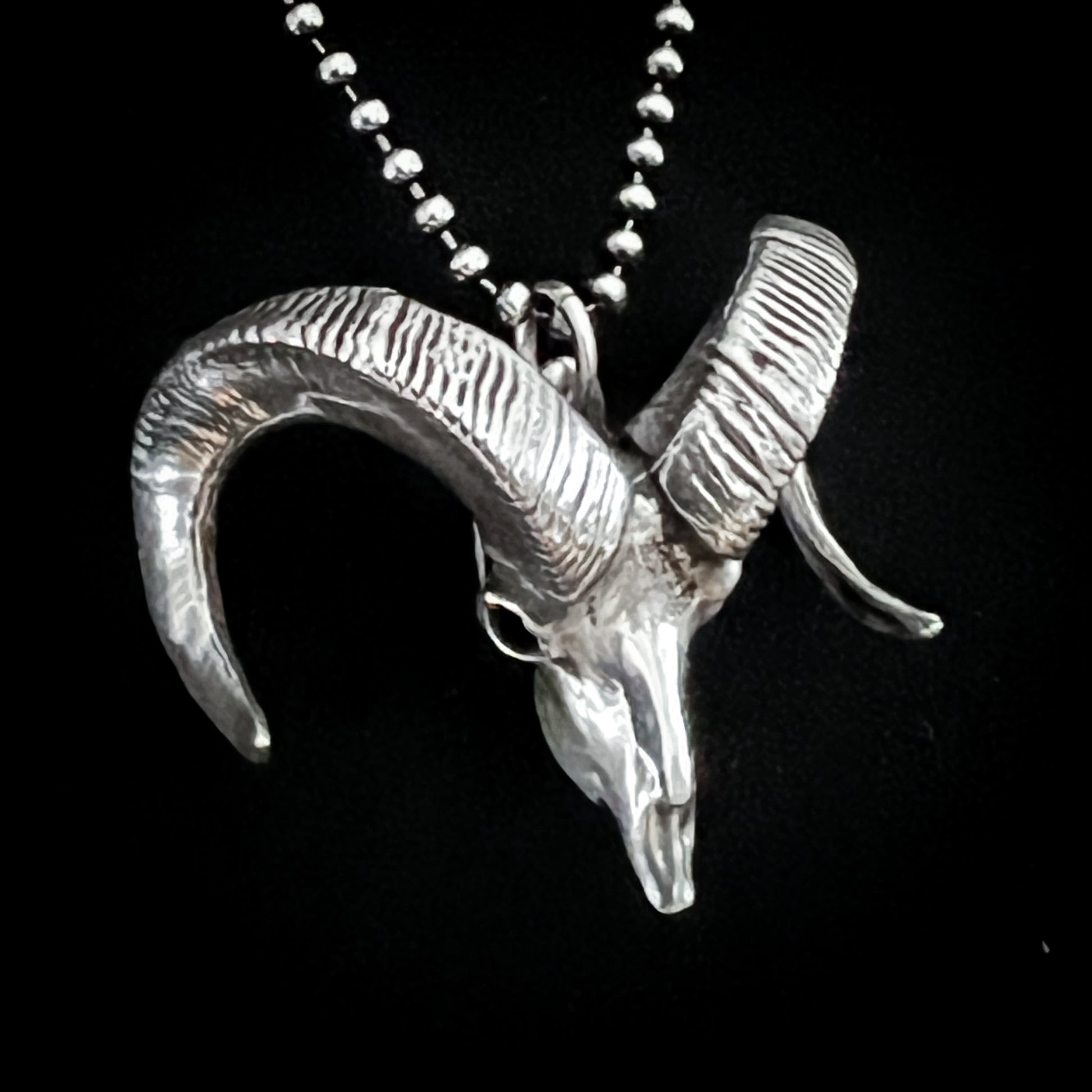 Sterling silver bighorn sheep skull pendant called Born to Headbang, shown close up