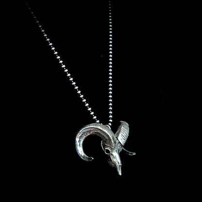 Sterling silver bighorn sheep skull pendant called Born to Headbang, shown from the side on a 24-inch ball chain
