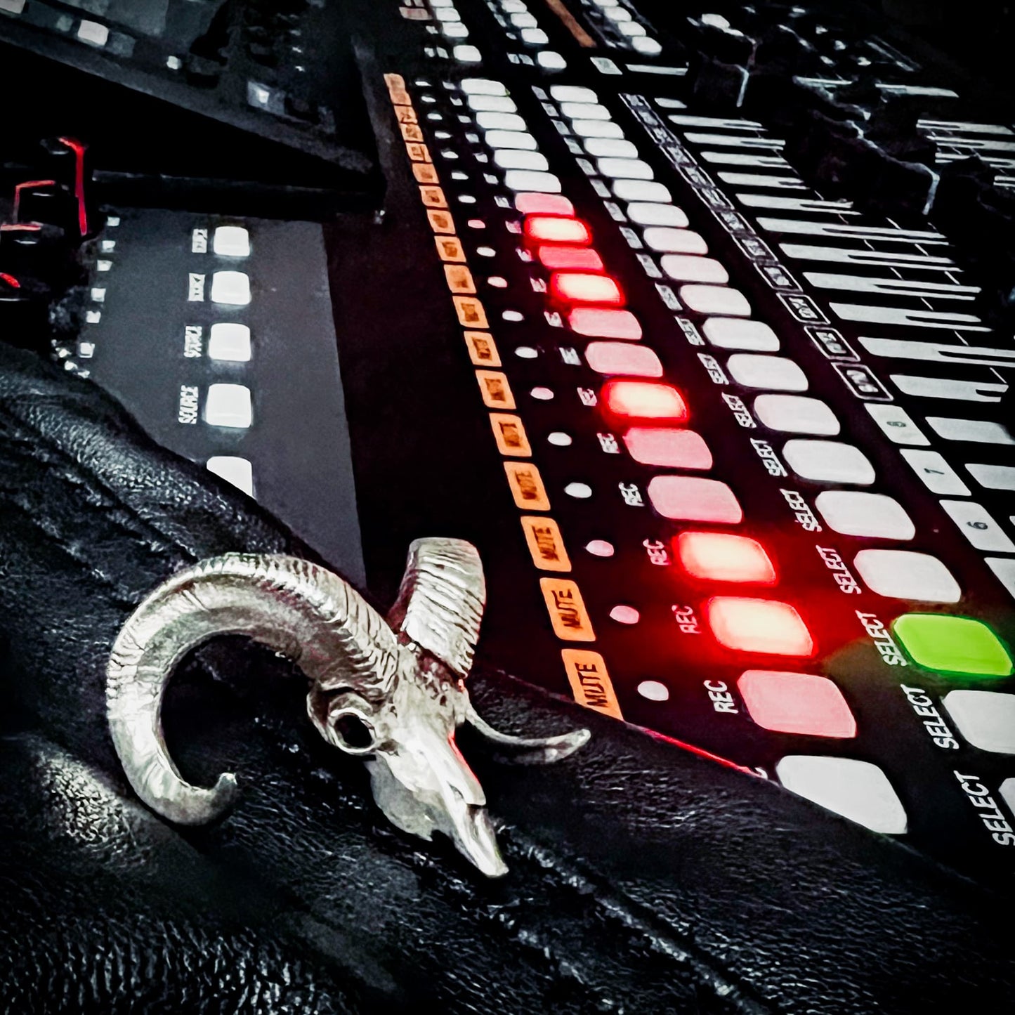 Sterling silver bighorn sheep skull pendant from ROCKSTAR★REFINEMENTS
styled on a recording desk with mixer faders, and glowing recording ights.
