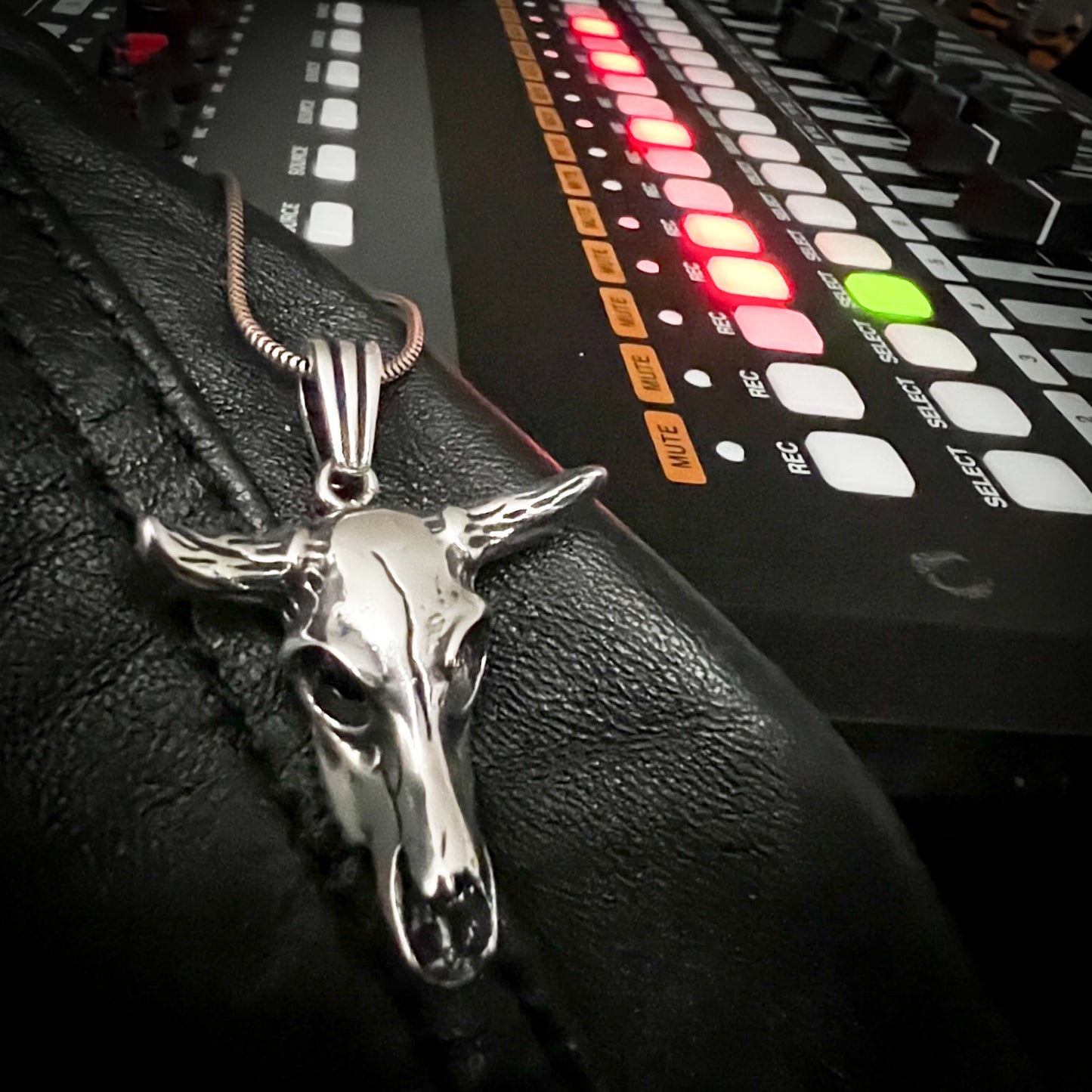 Sterling silver No BS bull skull pendant from ROCKSTAR★REFINEMENTS styled on a recording desk with faders
