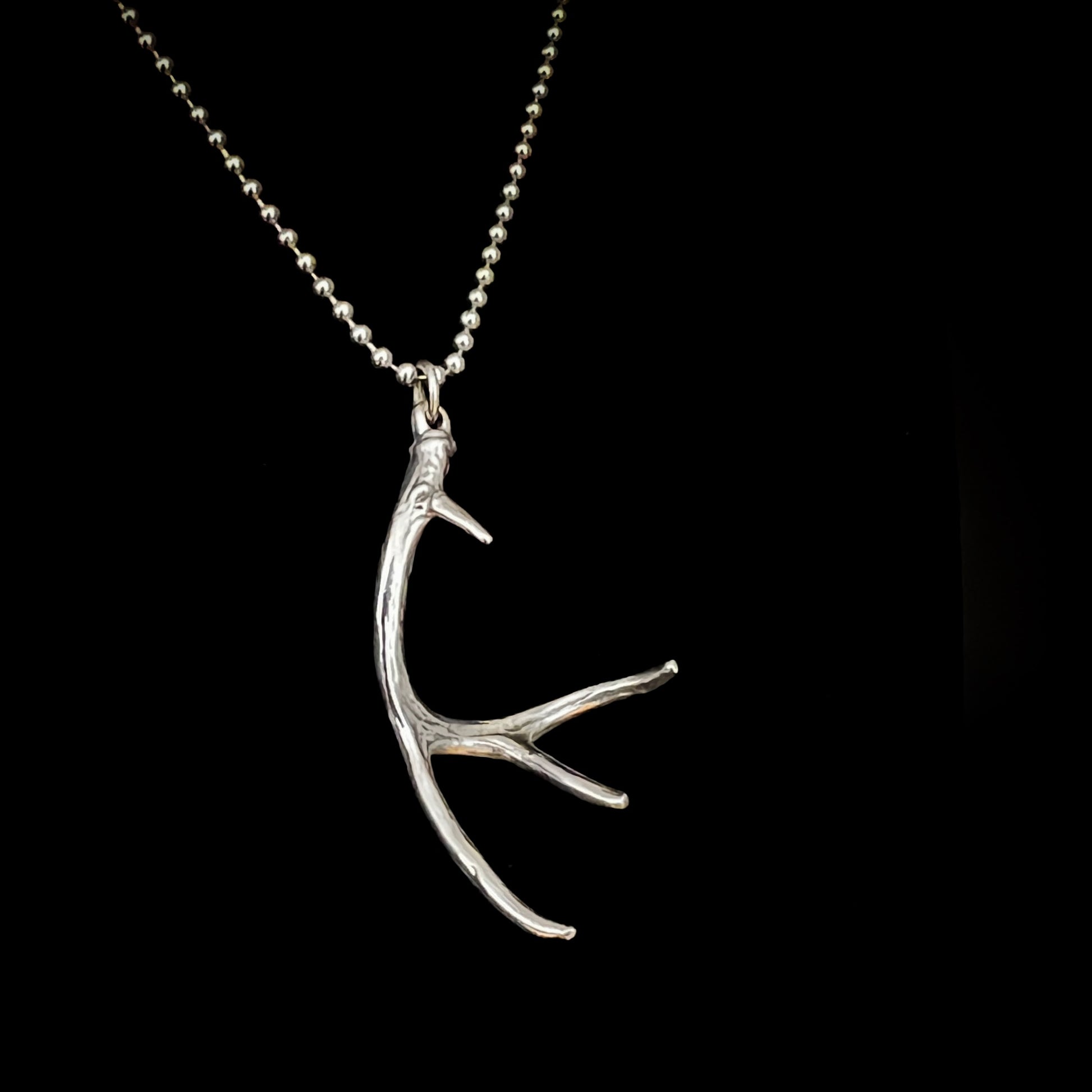 NO EYE DEER on high-shine ball chain photographed on black background 