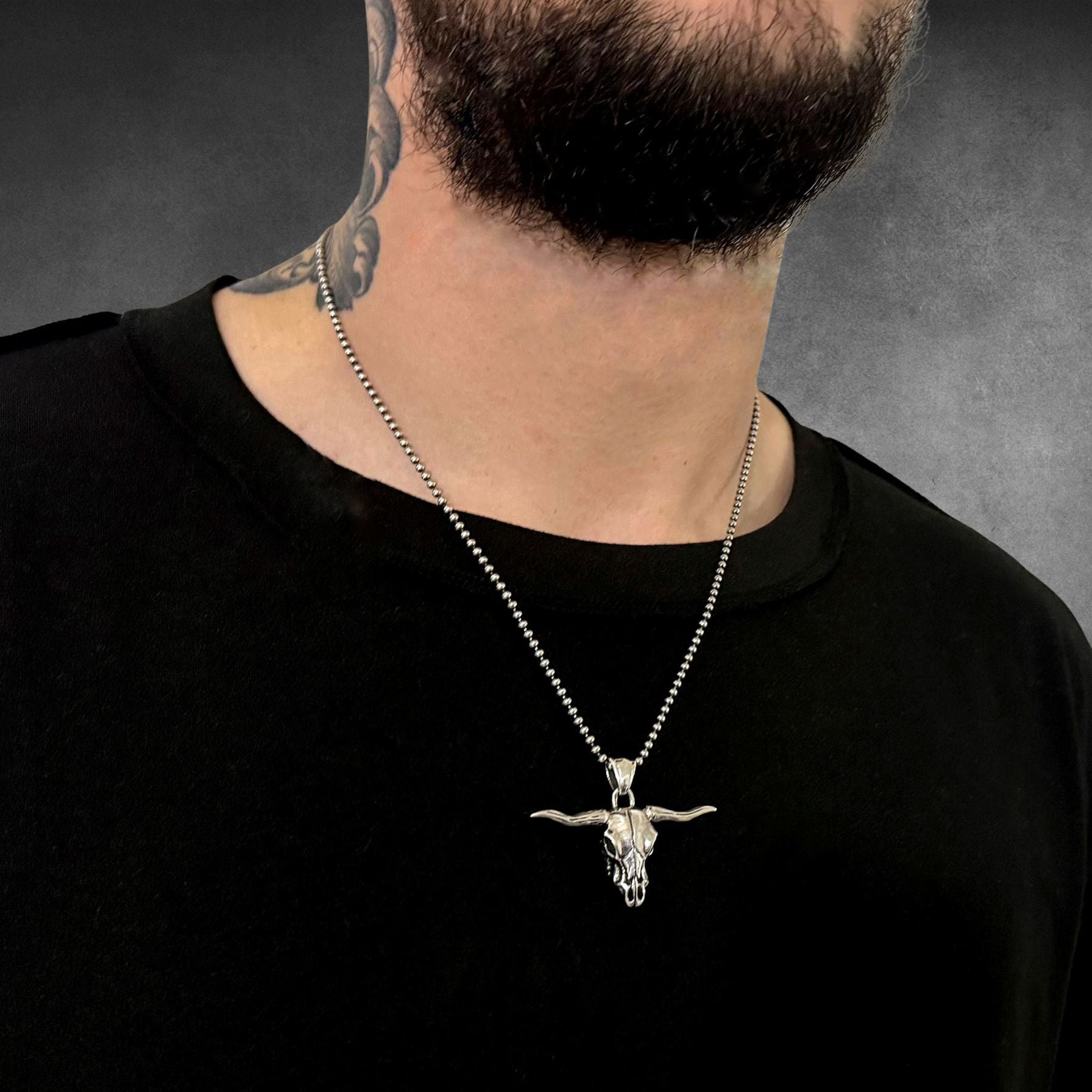 POINT OF NO RETURN worn by tattooed male model on 2.5mm ball chain, photographed on grey background