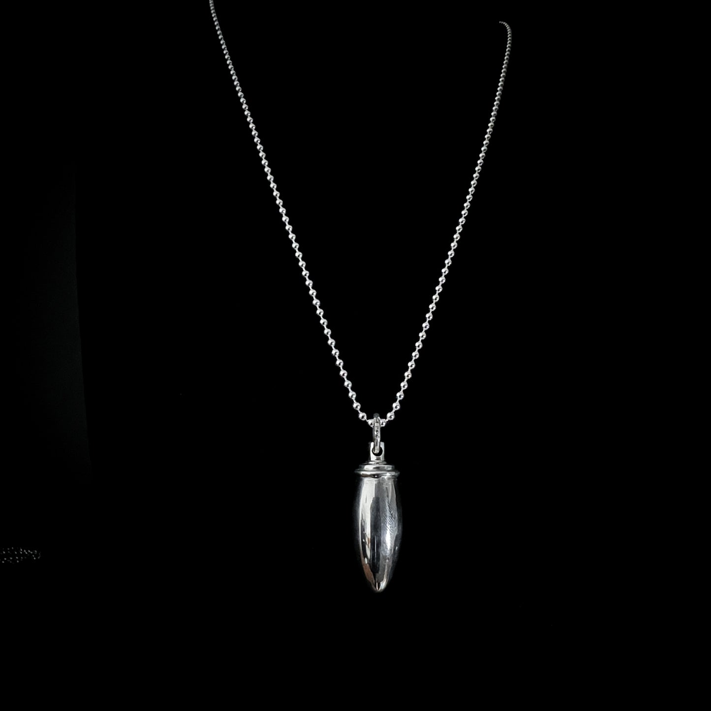 Silver pendant necklace on a black background