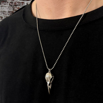 CROW'D CONTROL crow skull pendant worn by person in a black T-shirt