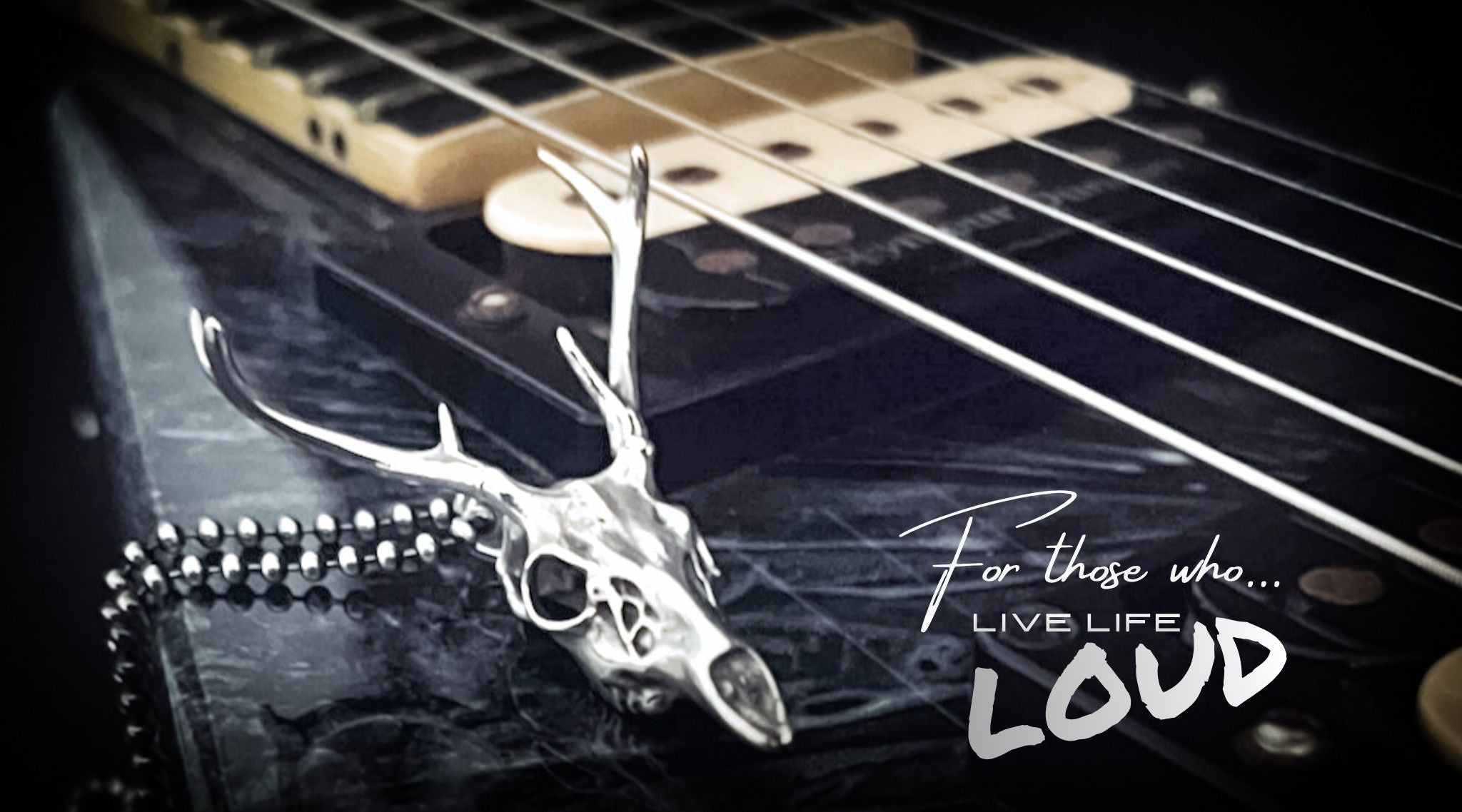 Sterling silver FAWN OF THE DEAD deer skull pendant by  ROCKSTAR★REFINEMENTS displayed on an Jackson V electric guitar