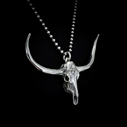 DON'T SQUAT WITH YER SPURS ON sterling silver pendant shown close-up on 24-inch oxidised ball chain, on black background