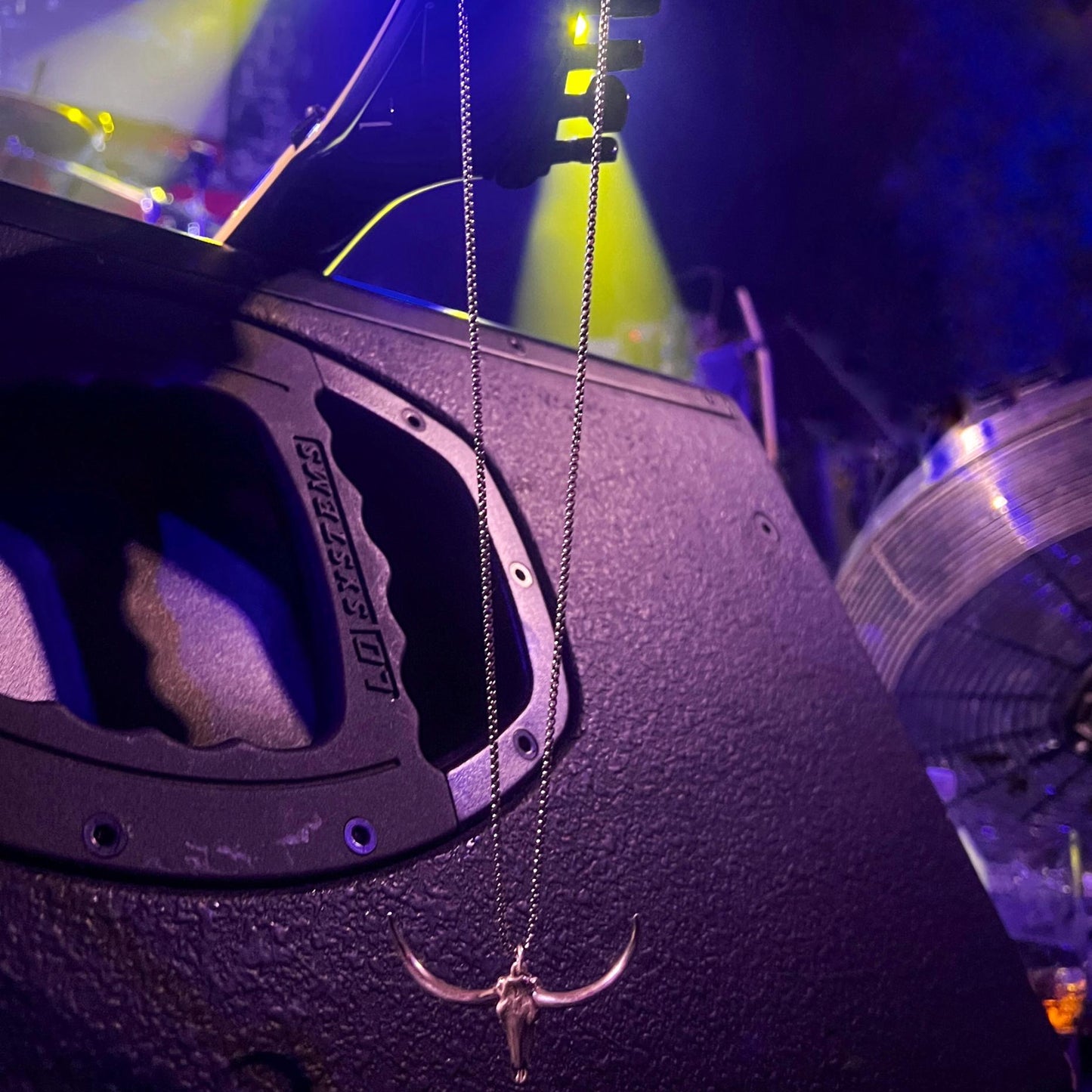 Jackson guitar resting on stage monitor with pendant hanging off the headstock