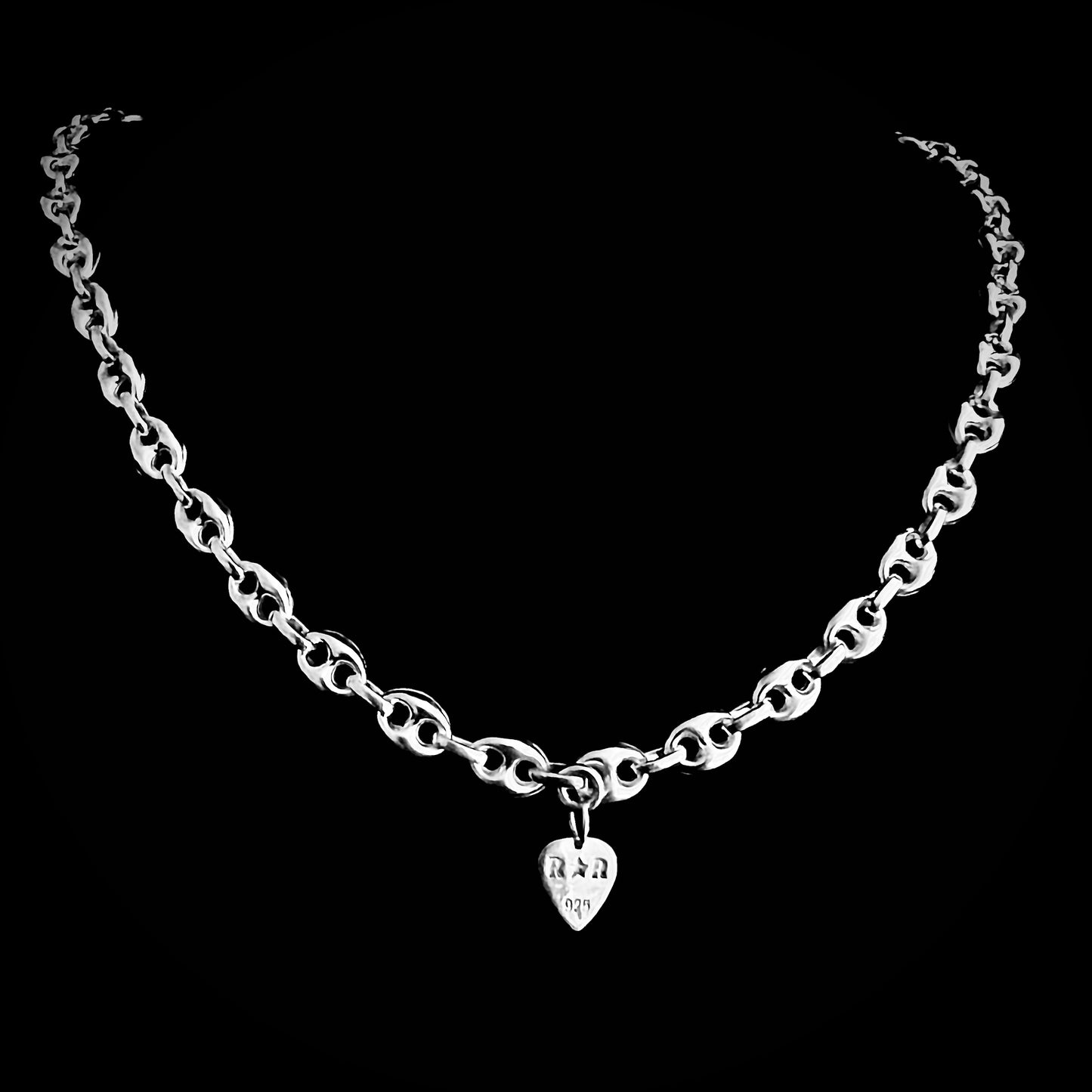 'DEFIANCE' — bold anchor chain necklace. Back of chain showing branded R★R jewellery tag. Photographed on black background.