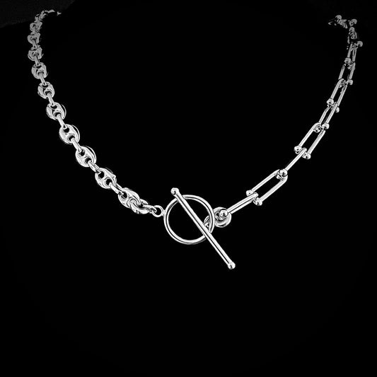 Sterling silver chain necklace with mixed anchor and architectural links on black background.