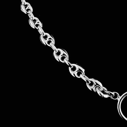 Close-up of sterling silver anchor links on black background.