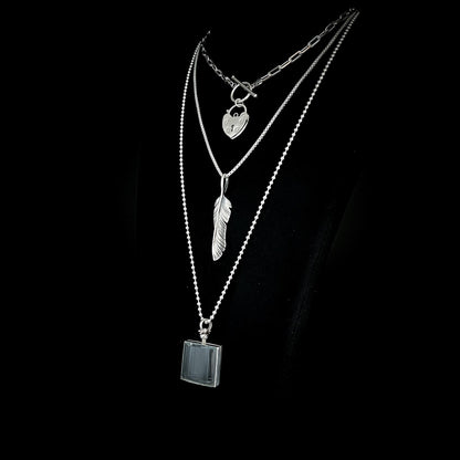 ACCESS DENIED, PLUCK OFF, and ASHES OF HIS HOODIE pendants from the EXES & EXCUSES collection by ROCKSTAR★REFINEMENTS™, layered on polished silver chains against a black background.