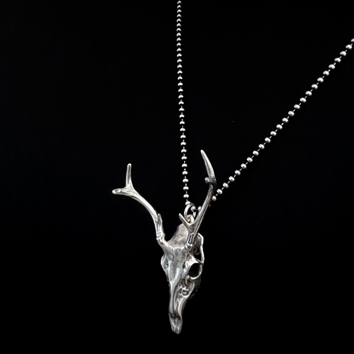 FAWN OF THE DEAD — sterling silver deer skull pendant on an oxidised ball chain, side view, photographed against a black background by ROCKSTAR★REFINEMENTS