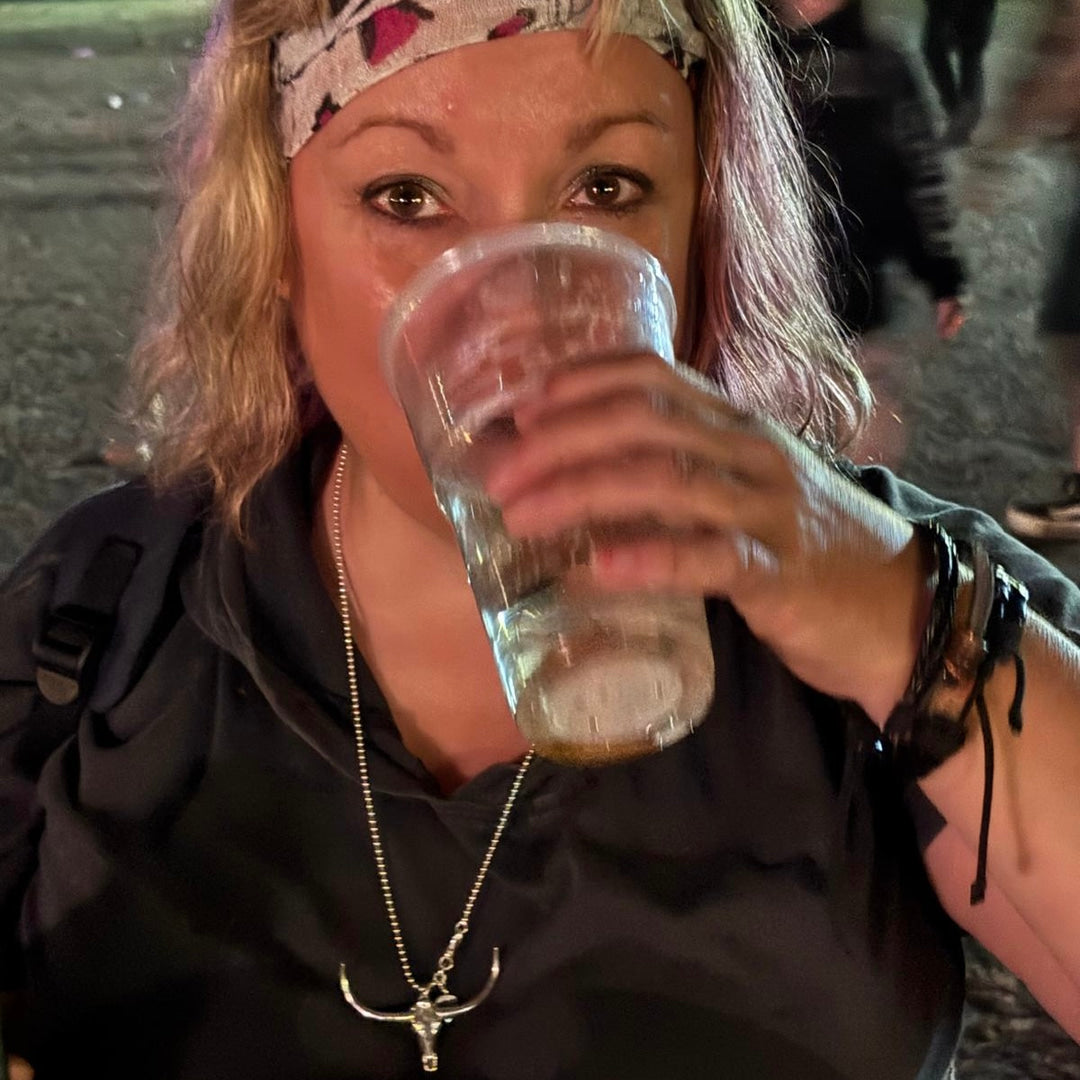 The Untamed at a festival, drink in hand, wearing the DON'T SQUAT WITH YER SPURS ON pendant.
