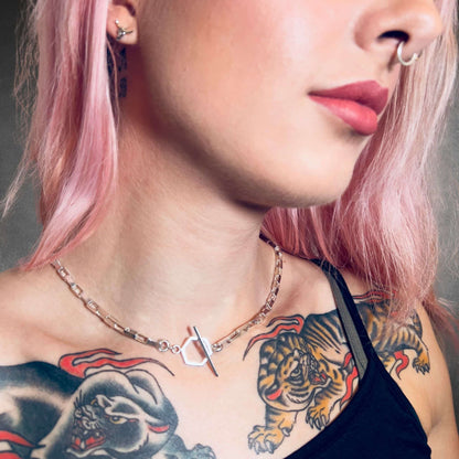 Close-up of a person with tattoos on their neck and shoulders, wearing the FULL STACK necklace by ROCKSTAR★REFINEMENTS™