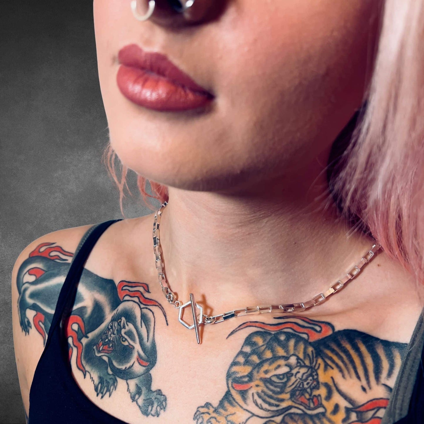 Close-up of a person with tattoos on their neck and shoulders, wearing the FULL STACK necklace by ROCKSTAR★REFINEMENTS™