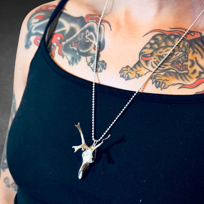 Person wearing a black vest top wearing the HORNOGRAPHY sterling silver skull pendant by ROCKSTAR★REFINEMENTS™