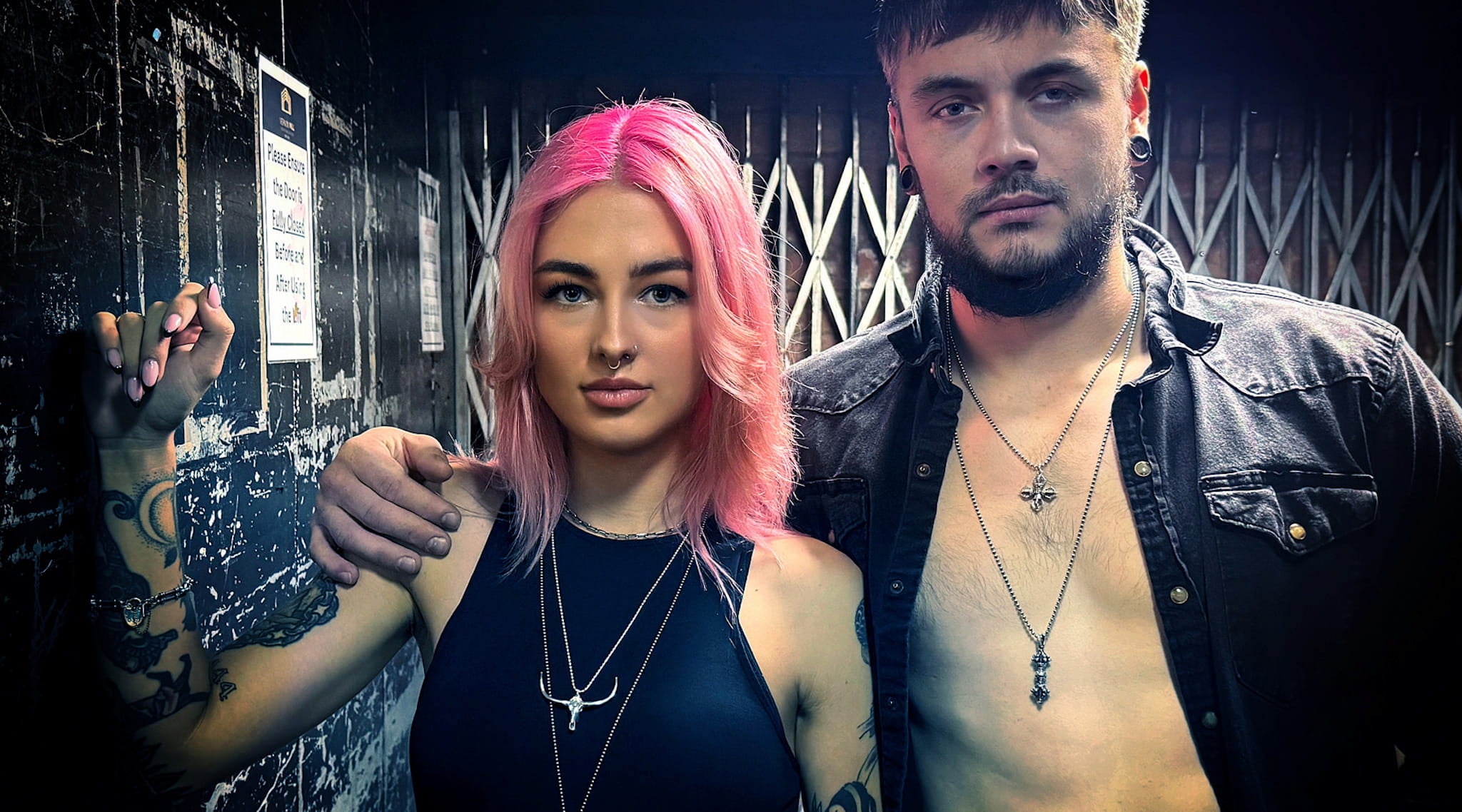 Models styled in layered sterling silver necklaces by ROCKSTAR★REFINEMENTS, photographed against a gritty industrial background.