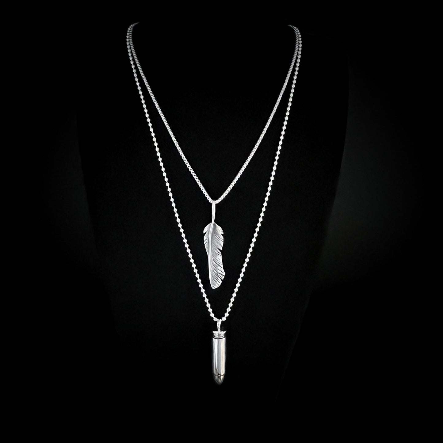 THE ONE STEP COOL KIT — sterling silver layered chains featuring WINGING IT on a 26-inch box chain and ONE HIT WONDER bullet pendant on a 30-inch 2.5 mm ball chain, photographed on a black background by ROCKSTAR★REFINEMENTS