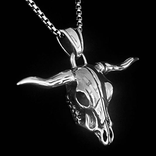 POINT OF NO RETURN silver bull skull pendant from ROCKSTAR★REFINEMENTS™, shown close-ip on a box chain against a black background.
