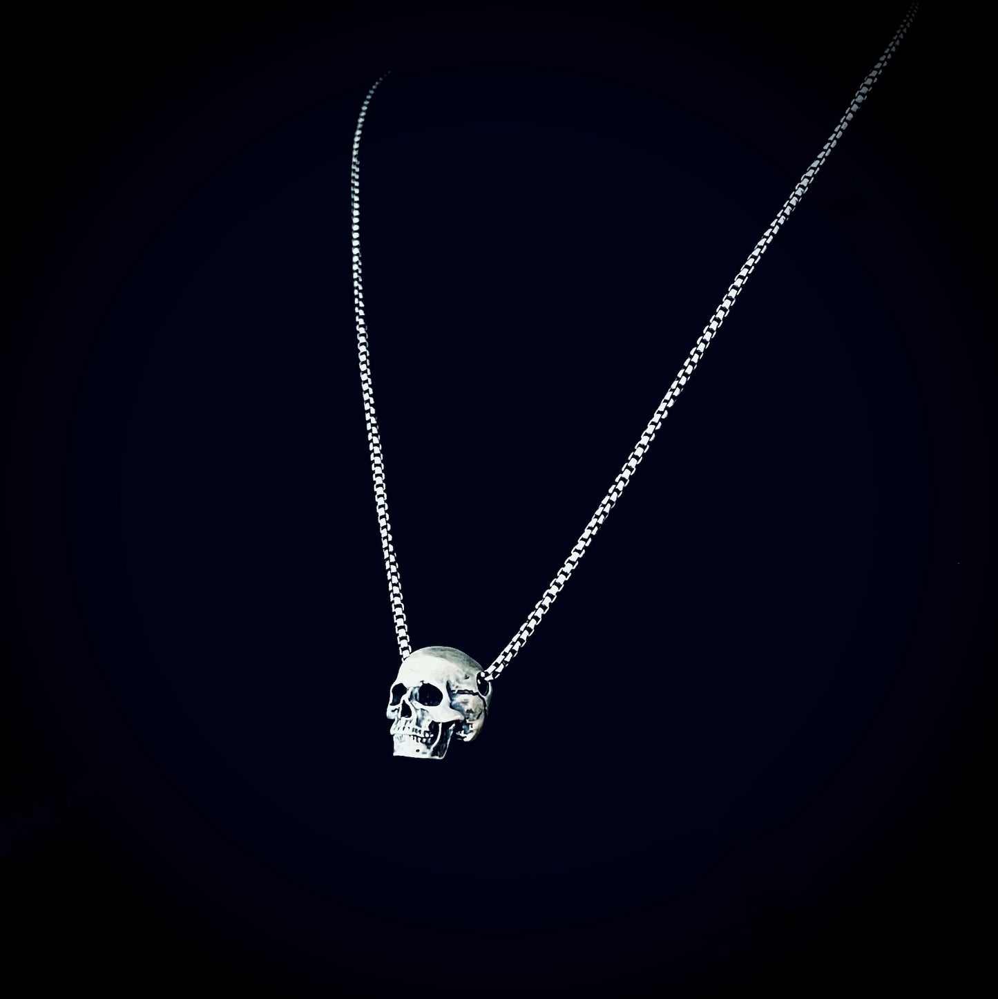 RESTING DEAD FACE — small sterling silver skull pendant necklace on a 22" box chain, photographed against a black background by ROCKSTAR★REFINEMENTS