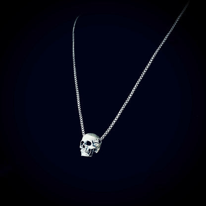 RESTING DEAD FACE — small sterling silver skull pendant necklace on a 22" box chain, photographed against a black background by ROCKSTAR★REFINEMENTS