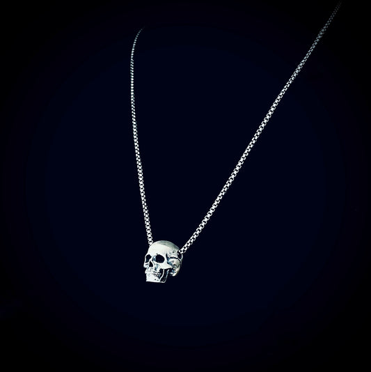 RESTING DEAD FACE — small sterling silver skull pendant necklace on a 22" box chain, photographed against a black background by ROCKSTAR★REFINEMENTS