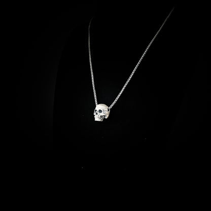 RESTING DEAD FACE — small sterling silver skull pendant necklace on a 22" box chain, photographed against a black background by ROCKSTAR★REFINEMENTS