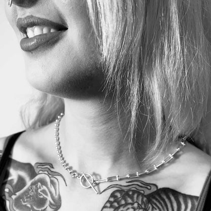 Black-and-white close-up of model wearing sterling silver SYNCED necklace by ROCKSTAR★REFINEMENTS™ 