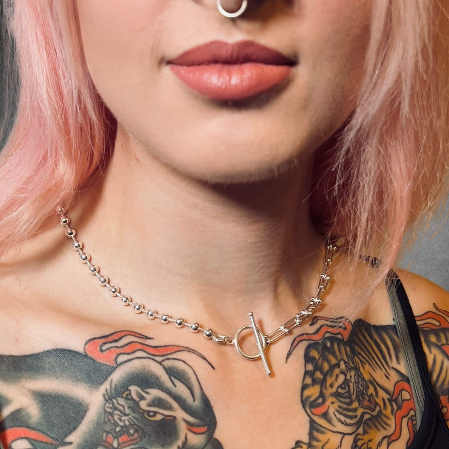 Close-up of a person with a tattooed chest wearing SYNCED sterling silver necklace by ROCKSTAR★REFINEMENTS™ 