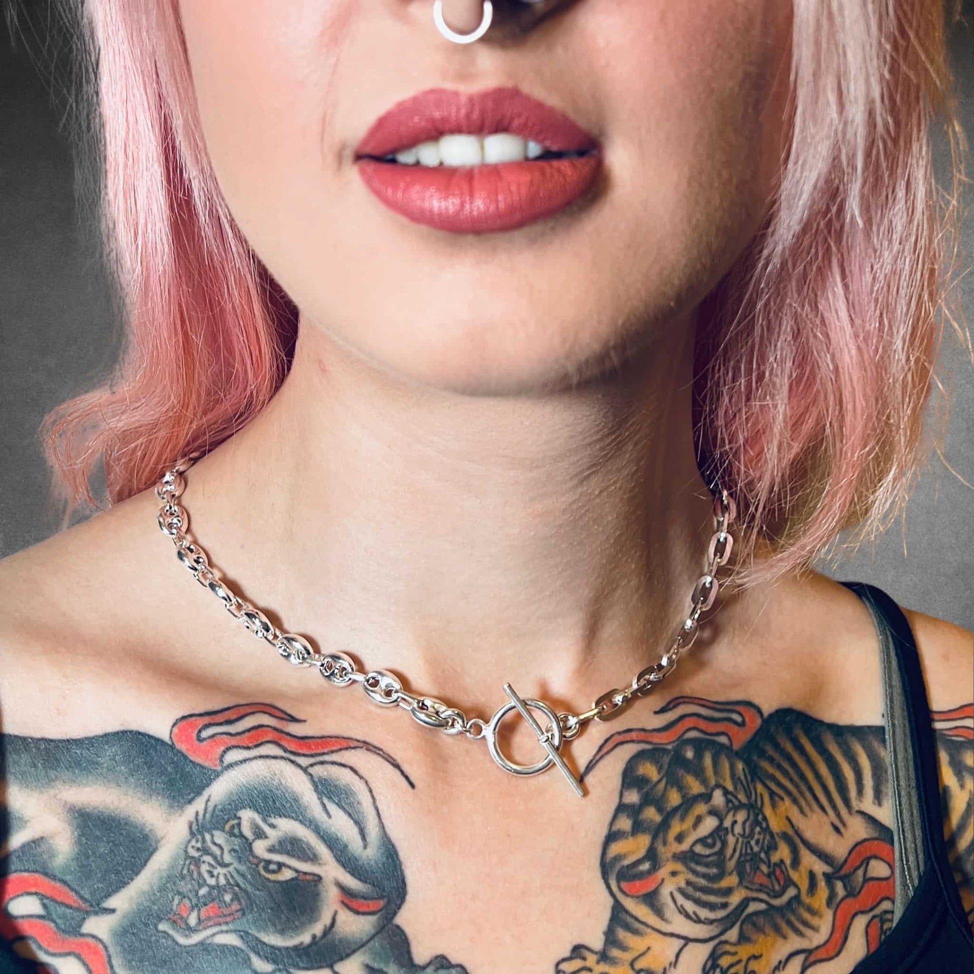 Close-up of a person with tattoos on their neck and shoulders wearing the TWIN LEAD sterling silver necklace by ROCKSTAR★REFINEMENTS™