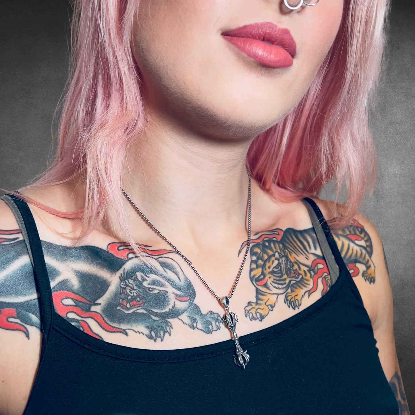 Tattooed person wearing the WARBORN MINI sterling silver pendant and ball chain by ROCKSTAR★REFINEMENTS™