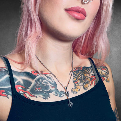 Tattooed person wearing the WARBORN MINI sterling silver pendant and ball chain by ROCKSTAR★REFINEMENTS™