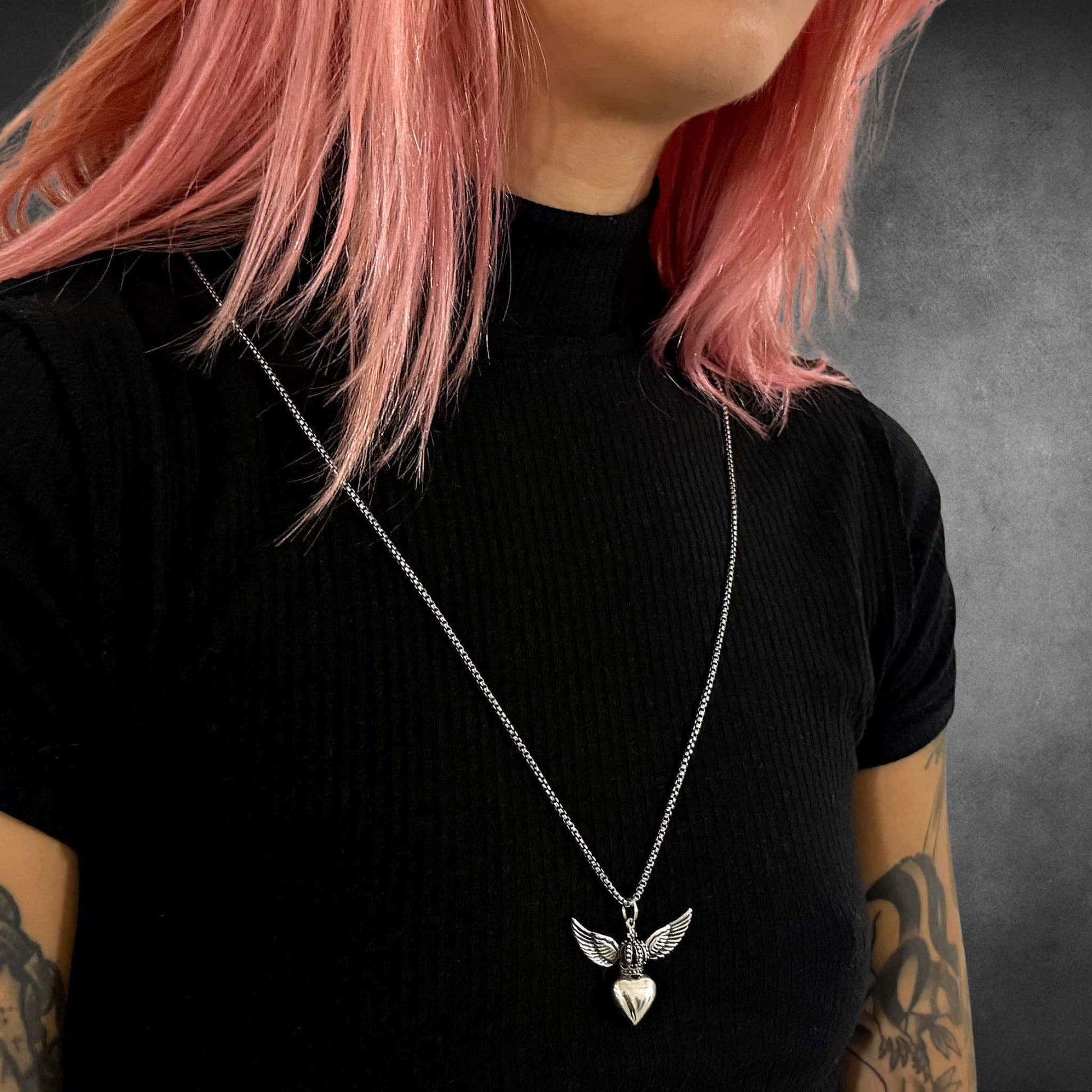 WILD AT HEART winged heart pendant on long sterling silver chain worn by model, side view