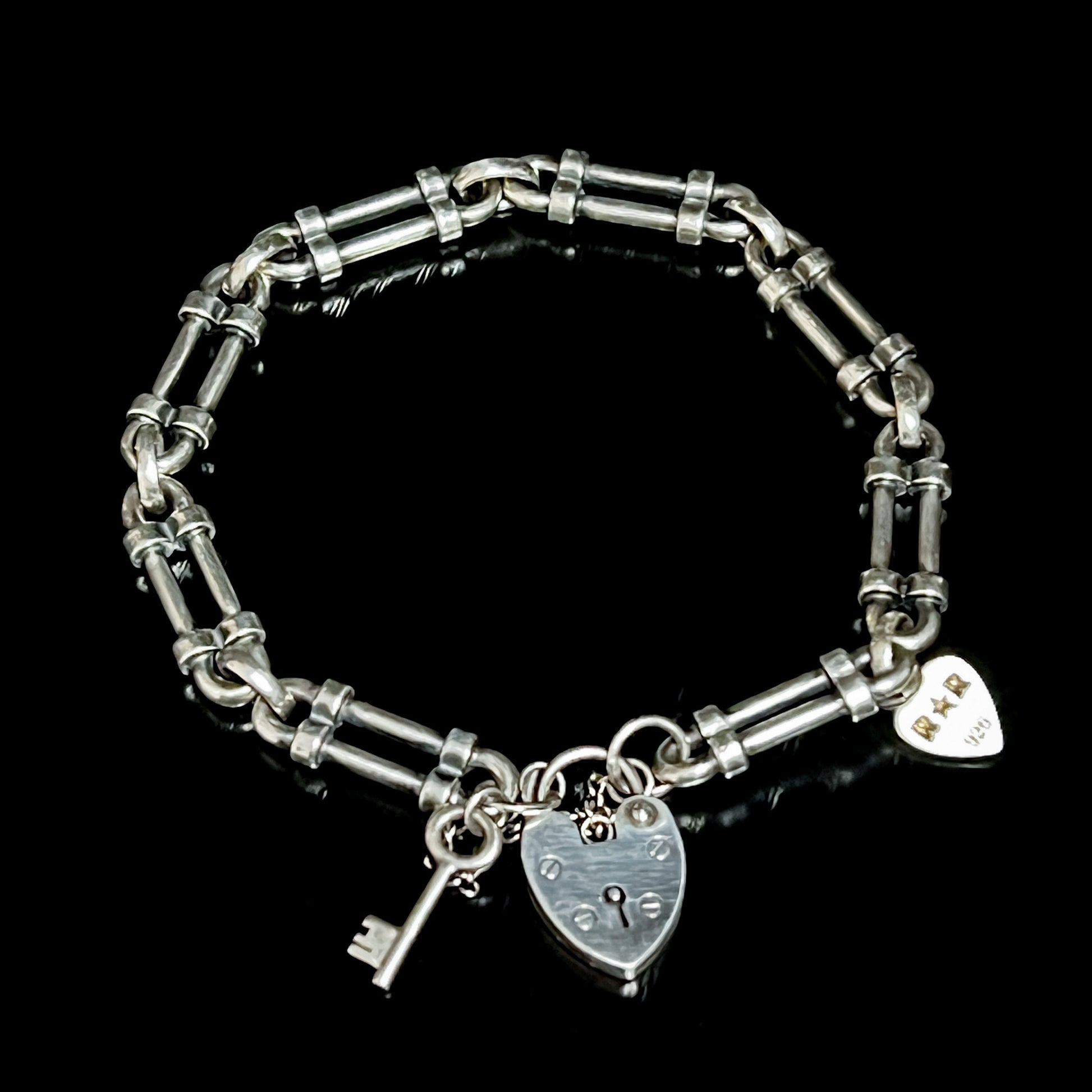 WRISTRICTED ACCESS oxidised sterling silver bracelet on a plain black background.