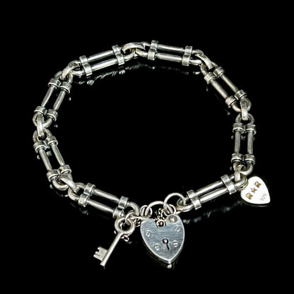 WRISTRICTED ACCESS oxidised sterling silver bracelet on a plain black background.